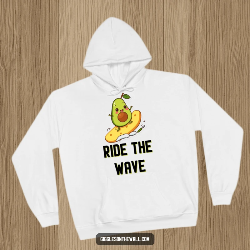 Funny avocado character surfing a giant chip, depicted on a cozy hoodie, offering warmth and a dose of playful, comical action.